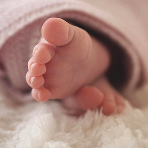 Foto van kleine baby voetjes op een teddy dekentje.